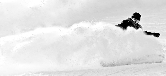 Atmospheric sports photography shot of a female snowboarder posing in action - winter portrait photography