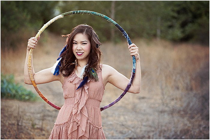 A teenage girl posing outdoors with a hula hoop