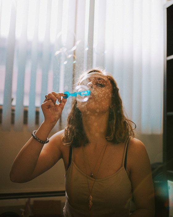 A portrait of a female model blowing bubbles shot with a wireless flash trigger
