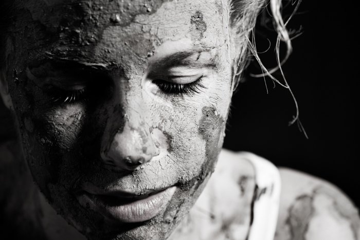 A black and white portrait of a female model covered in ceramic clay - photography lighting mistakes