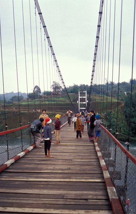 A group of people crossing a wooden bridge