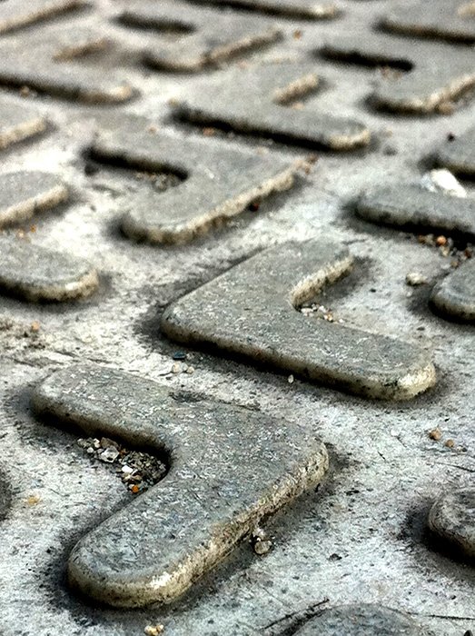 A low angle smartphone photo of a manhole cover