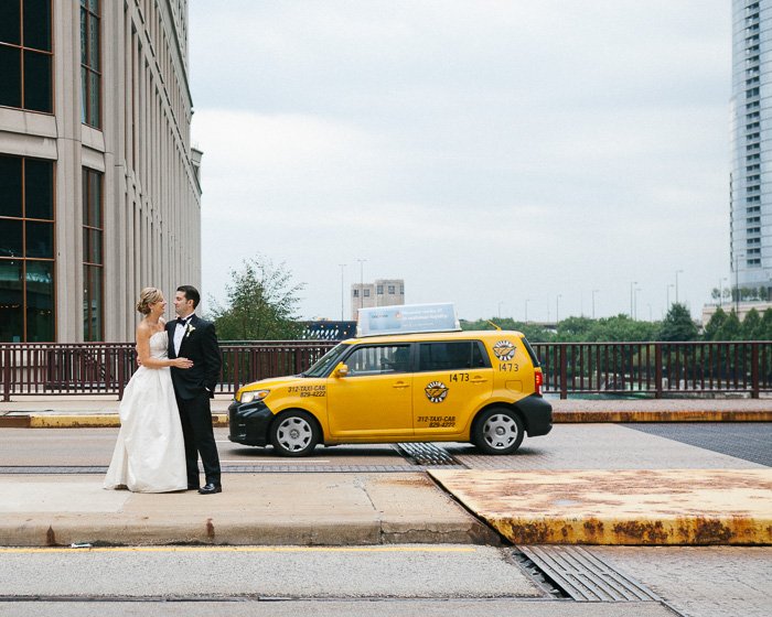 A newlywed couple posing beside the yellow cab of Downtown Chicago - capturing the decisive moment in photography