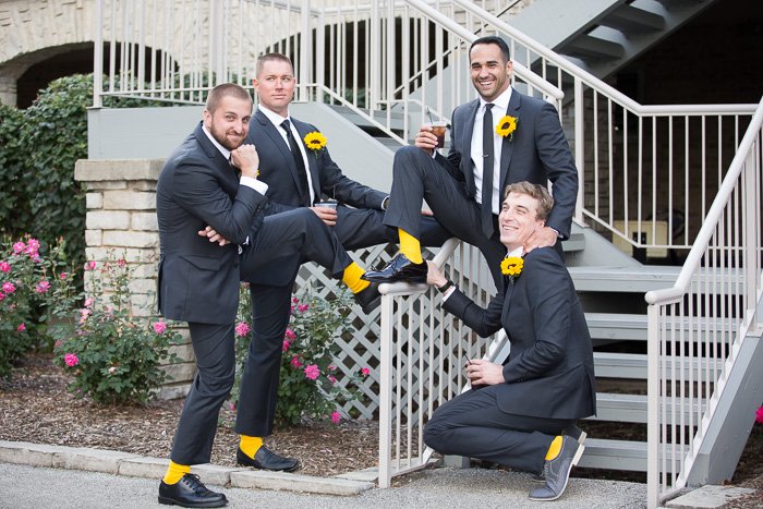A fun casual wedding portrait of a group of groomsmen hanging out and enjoying themselves. 