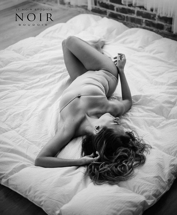 Overhead portarit of a boudoir model posing on a bed - boudoir photography business tips
