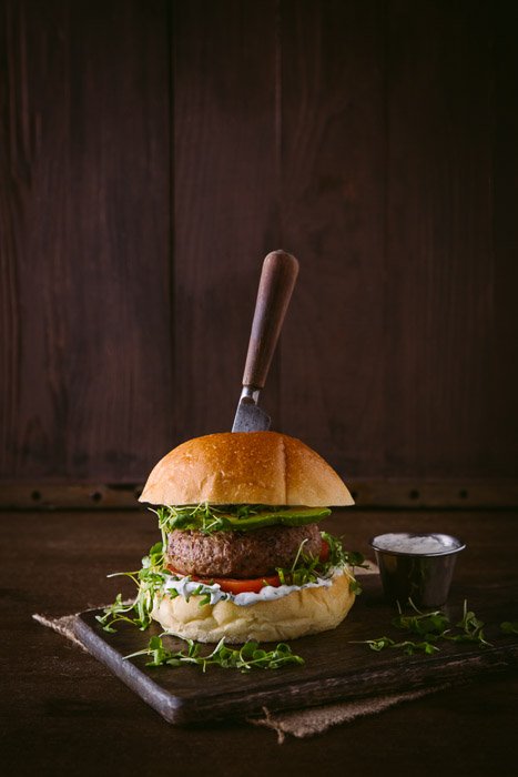 A delicious burger photo setup on rustic board and background 