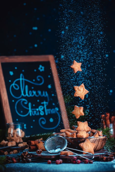 Christmas themed food still life including coffee cups, cookie cutters, sugar and cookies