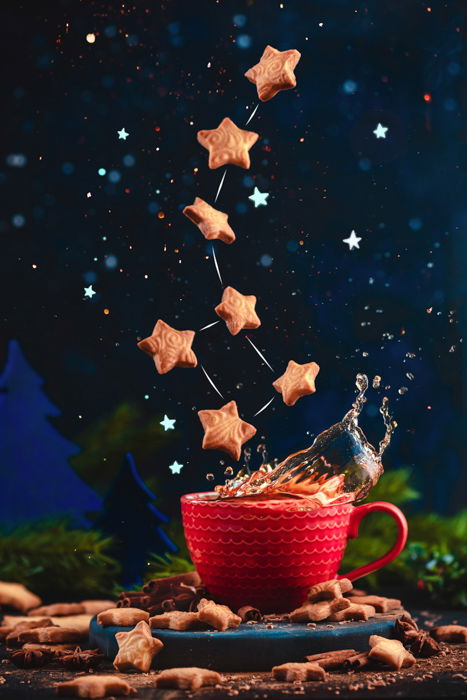 Creative food still life including coffee cups, sugar and flying star shaped cookies