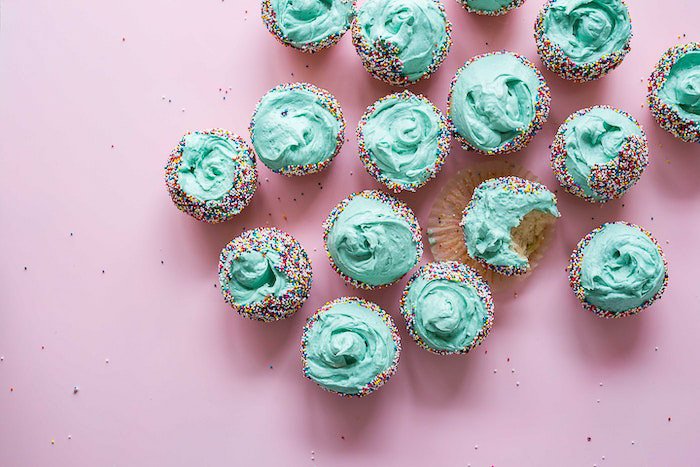 Overhead shot of a plate of green frosted cakes against a light background