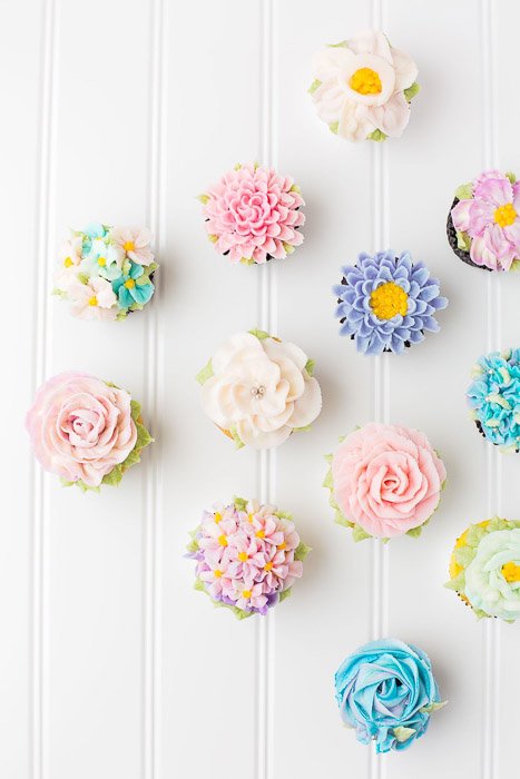 Overhead shot of flowery frosted cakes against a light background