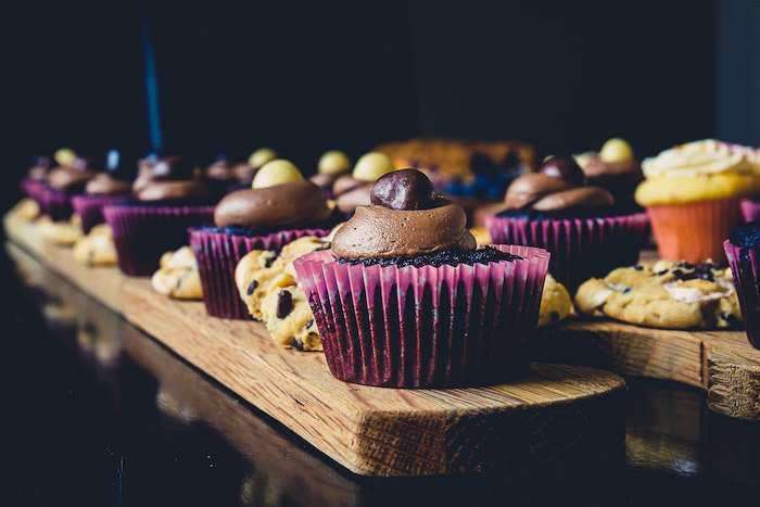 Atmospheric shot of cookies and cupcakes against a dark background