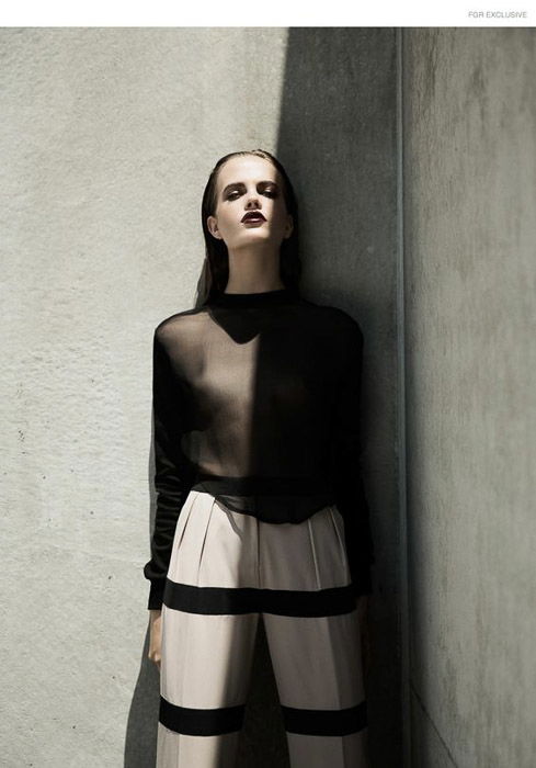 A striking image of a female model posing by a stone wall - fashion photo ideas