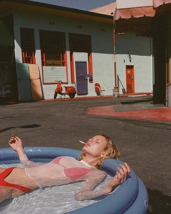 A blonde fashion model in a plastic swimming pool smoking a cigarette by v - fashion photography inspiration