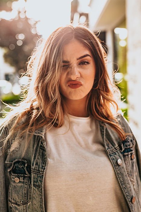 A fun portrait of a blond female model posing outdoors - how to photograph the female face 