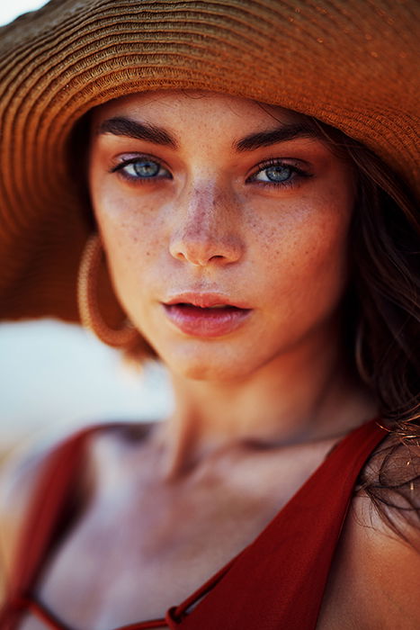 A stunning portrait of a female model in a sunhat - female face portrait