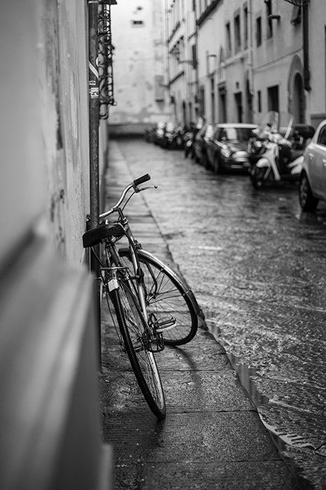A street photo of a bicycle leaning against a wall