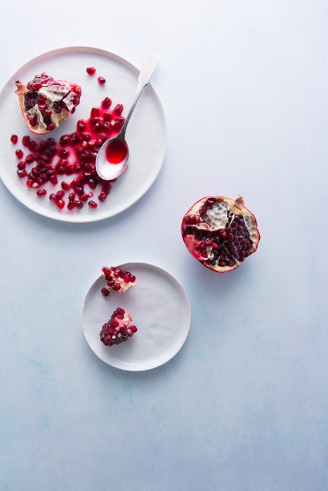 Bright and airy fruit photography flatlay of pomegranates in bowls