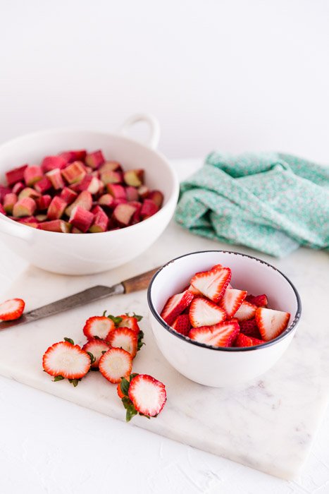 Bright and airy fruit photography shot of strawberries and rhubarb in a bowl