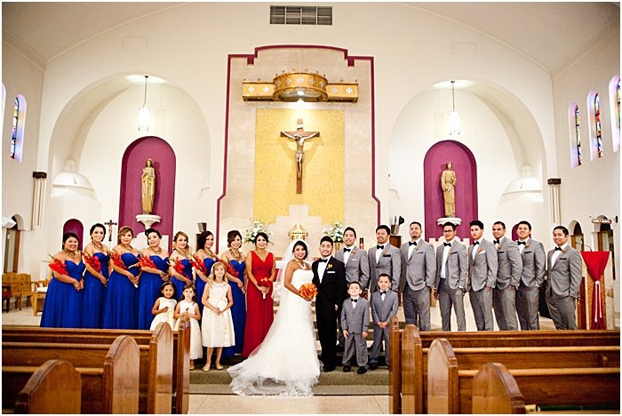 A group photo of a wedding party posing in a church - wedding flash photography