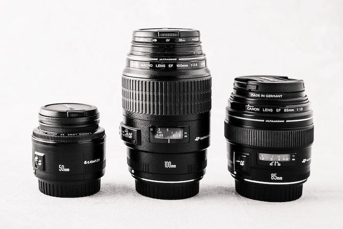 Three different photography lenses on white background - photography business equipment