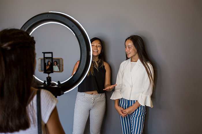 Two female models being photographed in a freelance photographers home studio setup