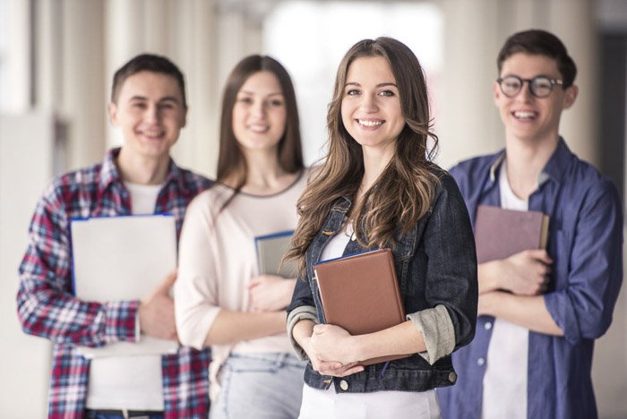 A Group of happy young students in a university posing with books - school portraits tips