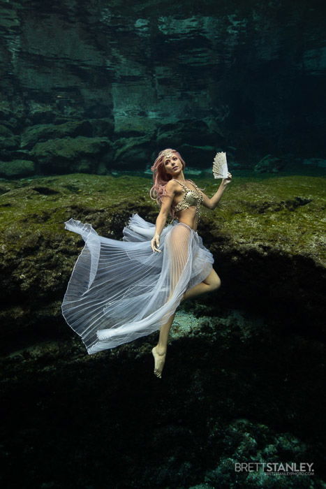 Dreamy underwater portrait of a female model swimming 