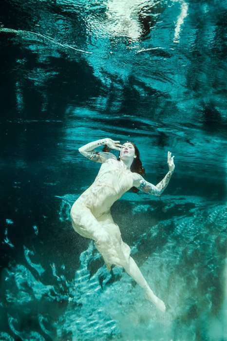 Dreamy underwater portrait of a female model swimming 