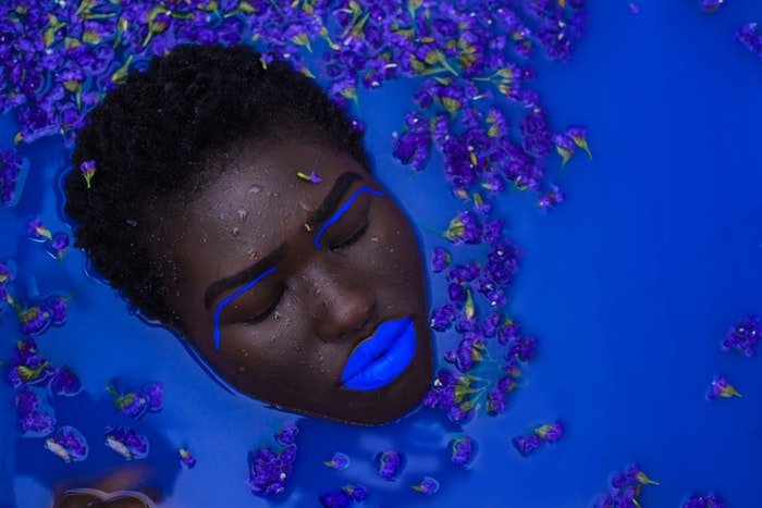 Woman's face with blue make up in blue water