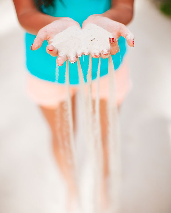 Sand slipping out of a woman hands.