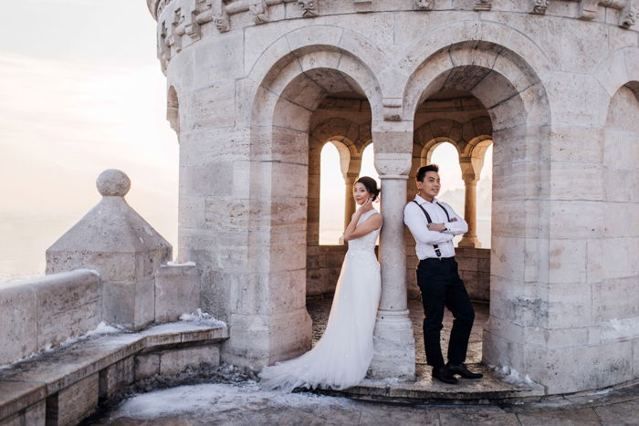 Artistic portrait of a newlywed couple posing in the tower of a classical building - fine art wedding photography 