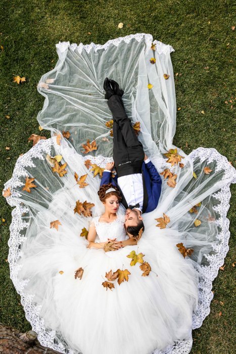 Artistic overhead shot of a newlywed couple lying on the grass - fine art wedding photography 