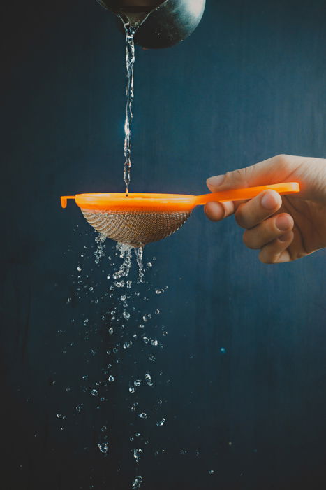 running water through a sieve to create a raindrop effect in still life photography