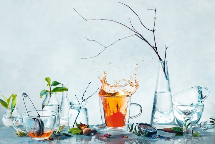 Artistic still life shot featuring teacups and foliage
