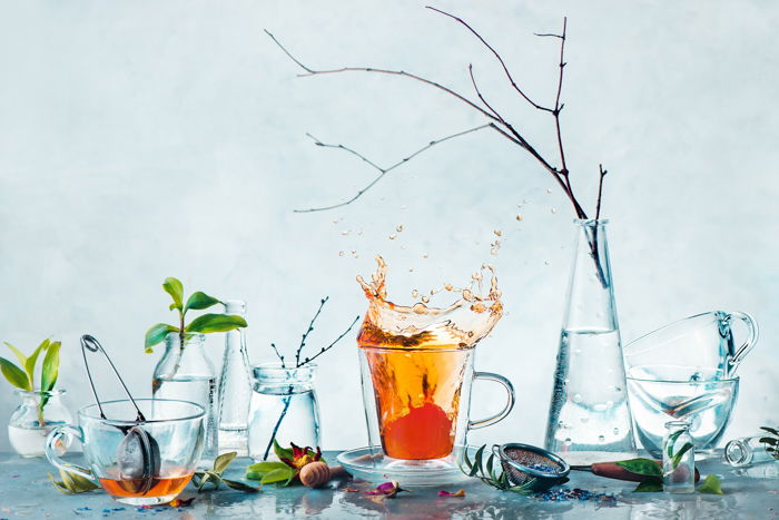 Artistic still life shot featuring teacups and foliage