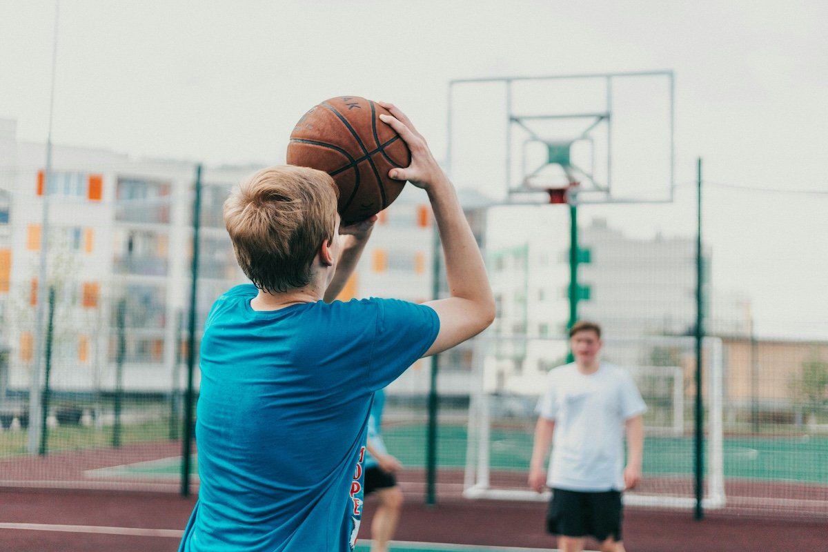 A person about to shoot a ball outside as an example of basketball photography