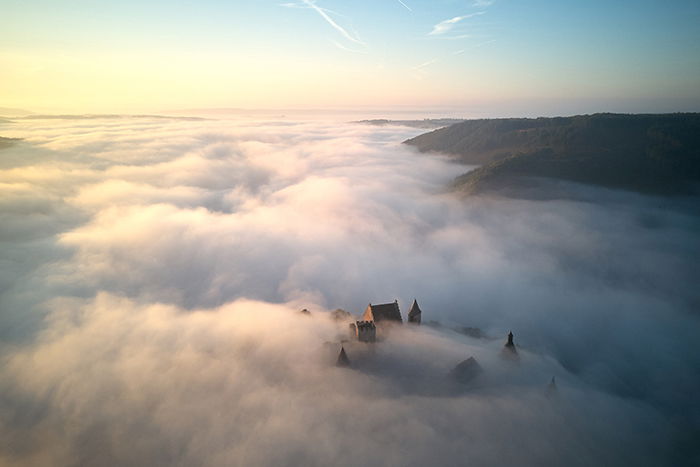 photo of a castle surrounded by clouds