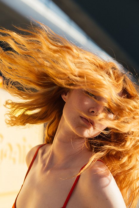 Stunning portrait of a girl tossing her auburn hair - beautiful photography principles