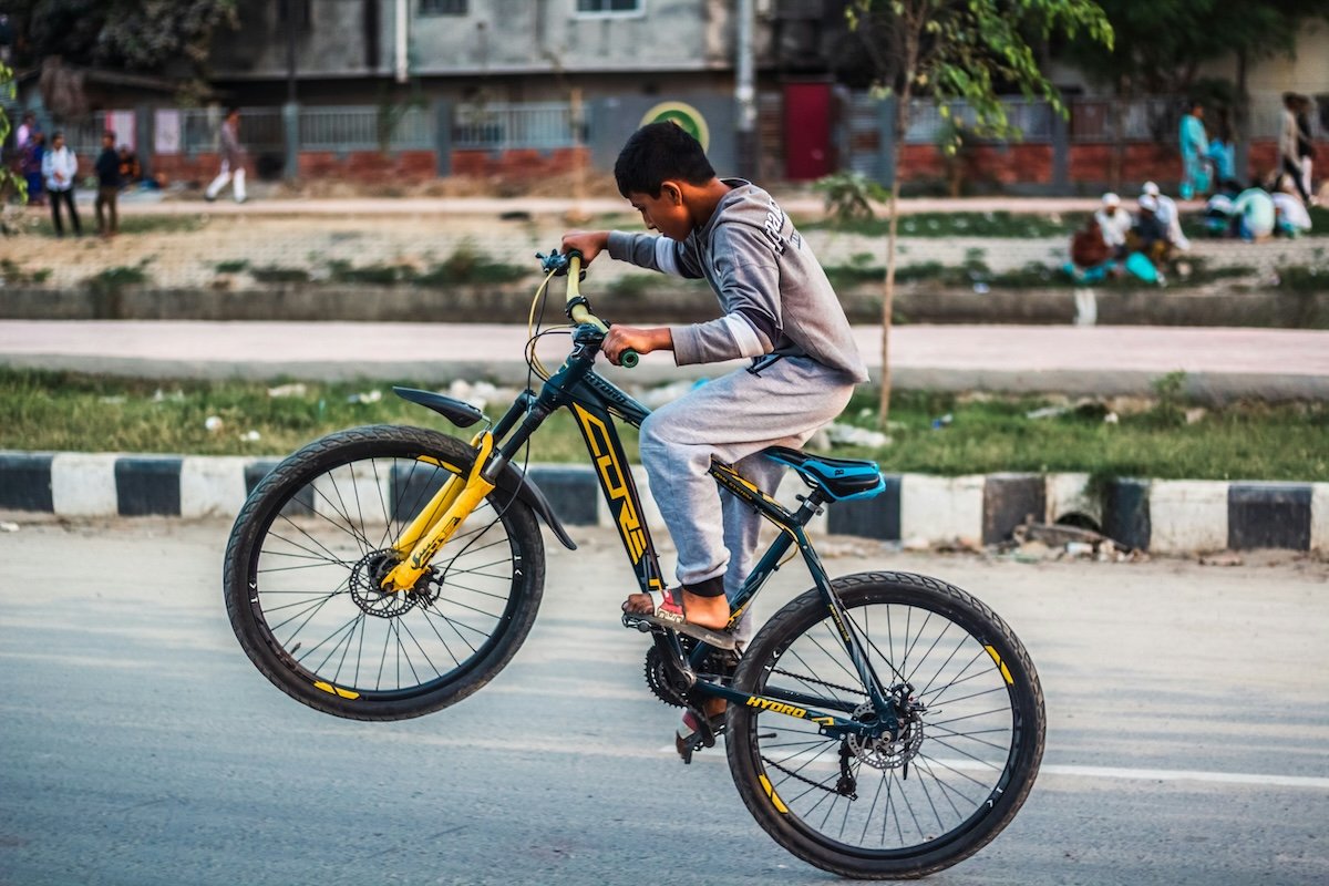 A kid popping up a front wheel on a bike to show burst mode