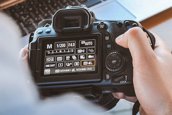 a photographer adjusting burst mode settings on a DSLR camera