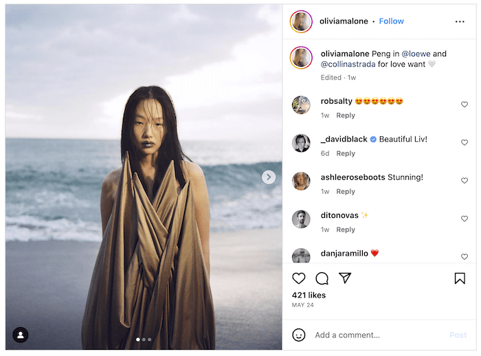 Screenshot of an Olivia Malone Instagram post of a draped fashion model by the ocean