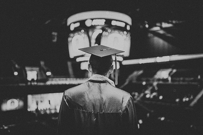 Candid monotone graduation portrait of a male student indoors