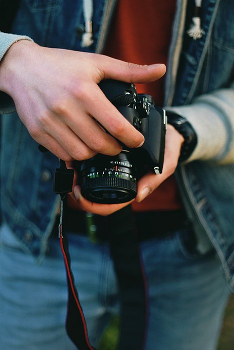A close up of a person holding a DSLR camera - heart shaped bokeh tutorial 