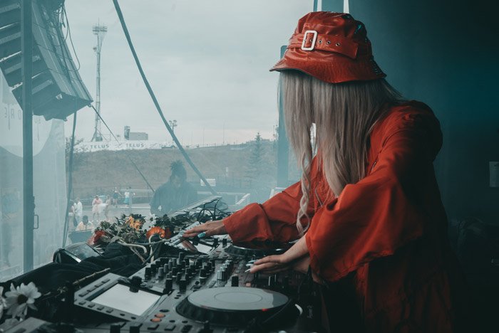 A portrait of a female dj playing onstage - festival photography