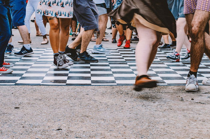 The feet of an active music festival crowd