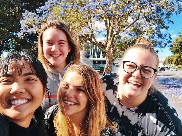 A group selfie of smiling people outdoors