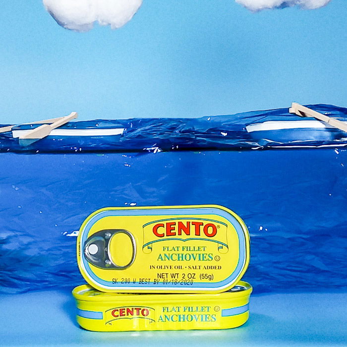 smartphone product photography shot of cans of anchovies on painted background 