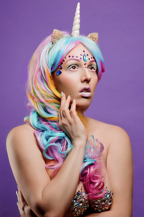 Creative boudoir self portrait of a female model in a unicorn costume 