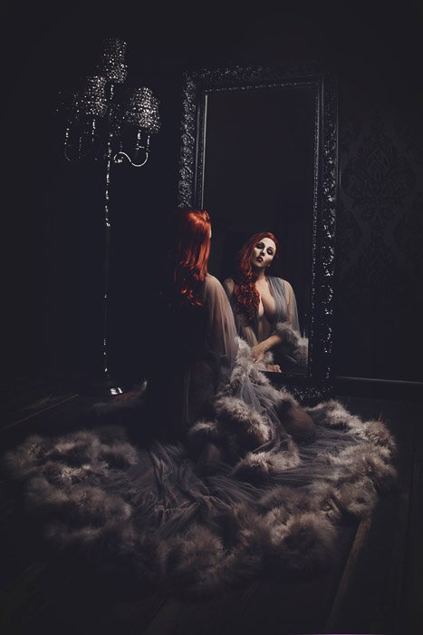 Atmospheric self portrait boudoir photography of a female model posing in a Gothic style interior