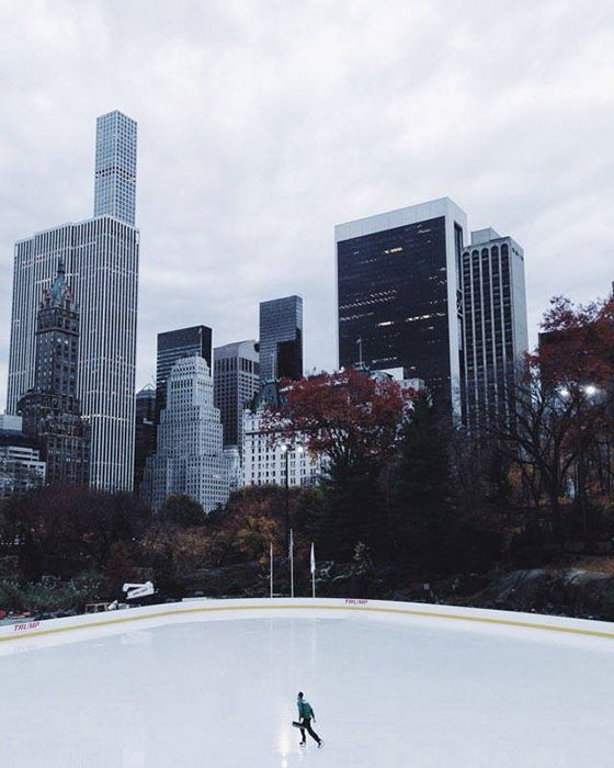 n outdoor ice skating rink beneath tall skyscrapers 